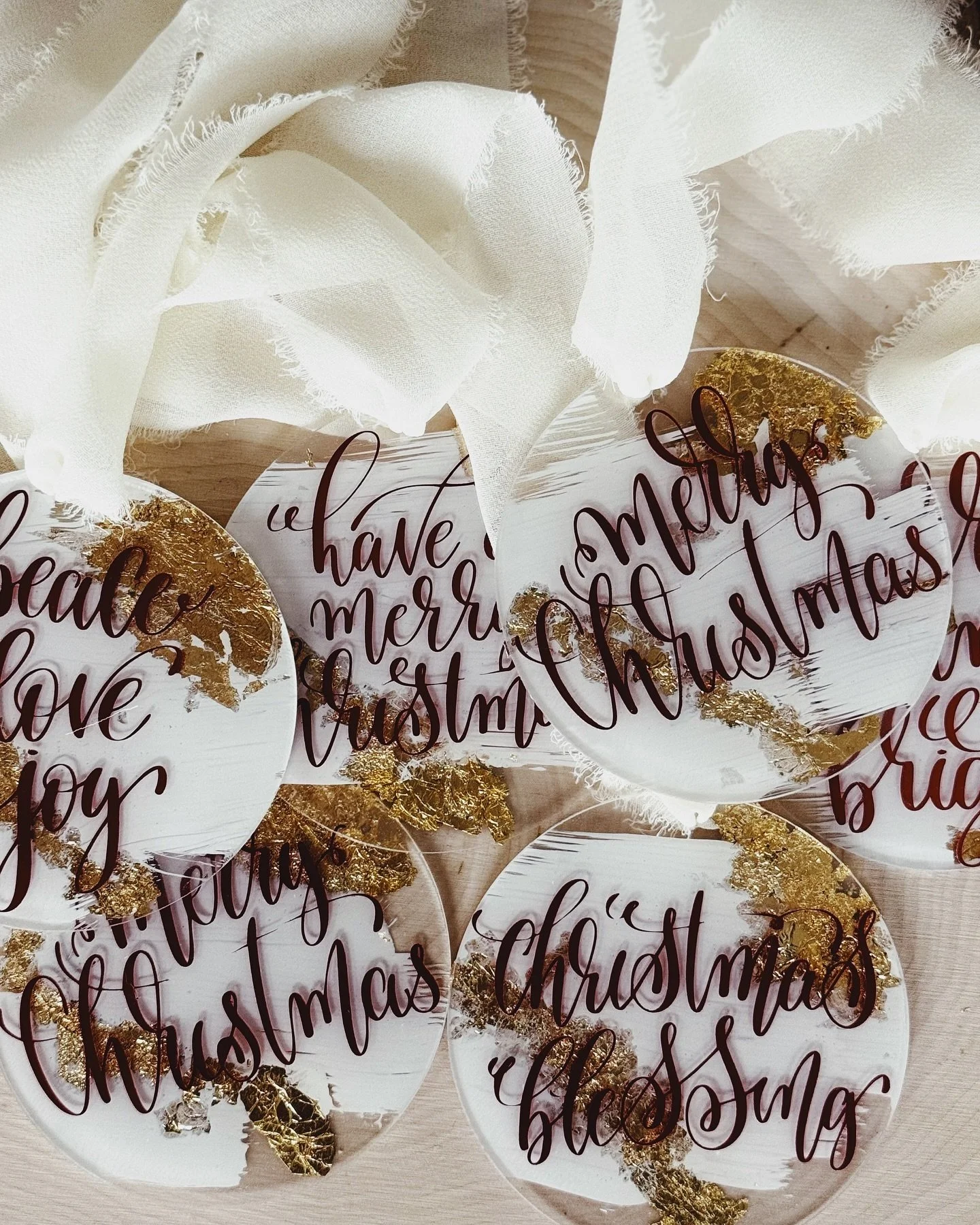 Acrylic Christmas ornaments with brown calligraphy and gold leaf — peace, love, joy, merry christmas